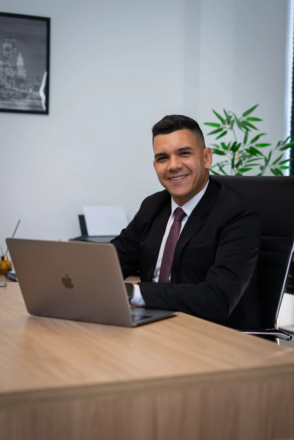 Helder Nangino em seu escritório, sentado à mesa de atendimento