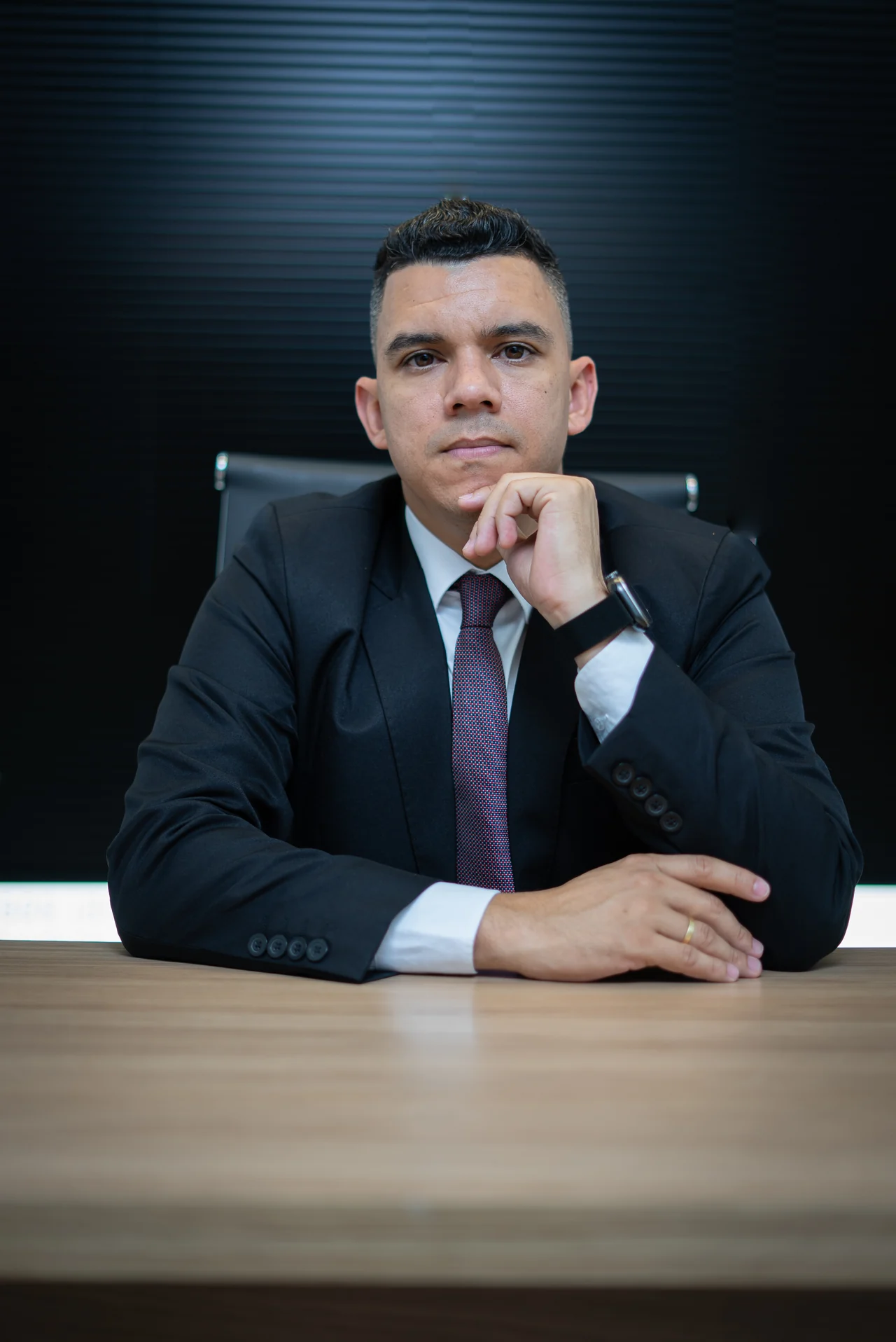 Advogado Helder Neemias Nangino sentado à mesa em seu escritório